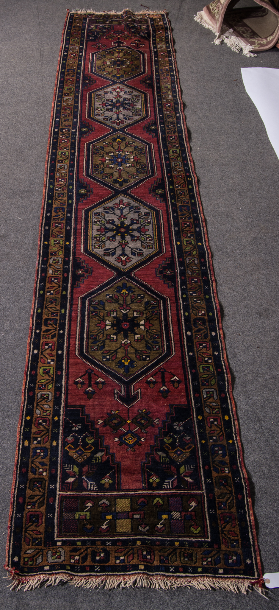 Beluchi runner, central field in red with stylised geometric decoration, 380 x 72cms.