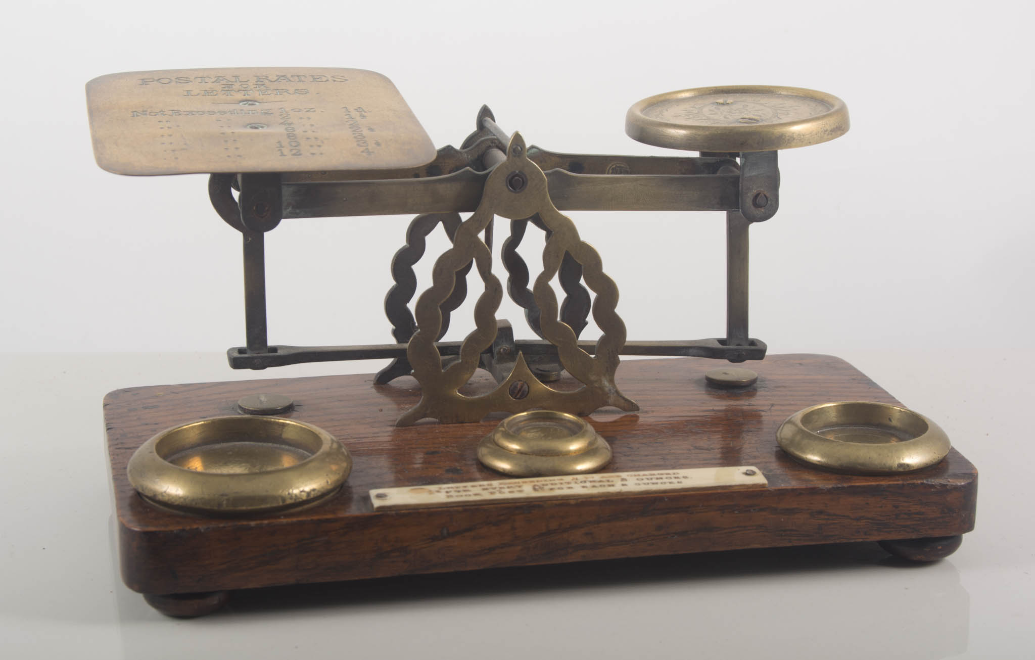 A set of oak and brass postal scales and weights, 23cms.