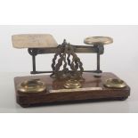 A set of oak and brass postal scales and weights, 23cms.
