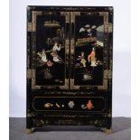 A Chinese lacquered cabinet, rectangular form, two panelled doors, decorated figures above a drawer,