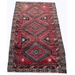 Belouchi rug, red ground with three lozenge medallions on a pole within multiple borders,