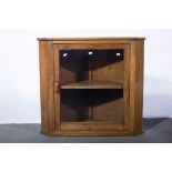 Oak wall mounted corner cabinet, with glazed door revealing single shelf, 77cms wide, 71cms high.