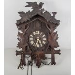 Continental carved and stained wood Cuckoo clock, the dial with Roman numerals,