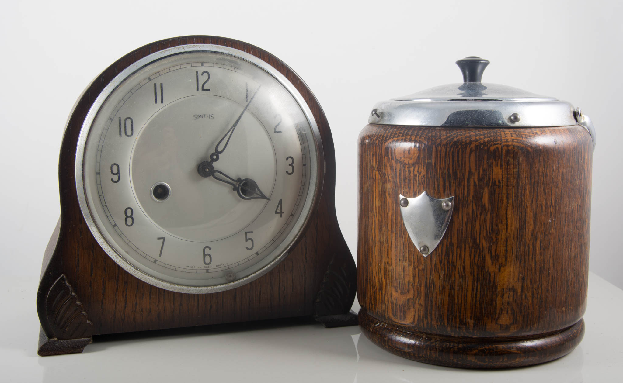 Oak mantel clock, height 20cm, pair of oak candlesticks and an oak biscuit barrel, (4).