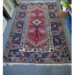Caucasian rug, central lozenge medallion on a pole, red field, border within guards,