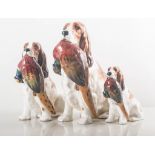 Set of three Royal Doulton graduating models, seated dogs with pheasants HN1001, height 17cm,