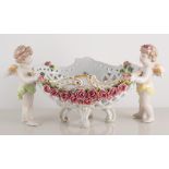 Continental porcelain centre bowl, with cherub to either side of the lattice ware basket,