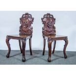 A pair of Victorian mahogany hall chairs, cartouche shaped backs, solid seats, cabriole legs.