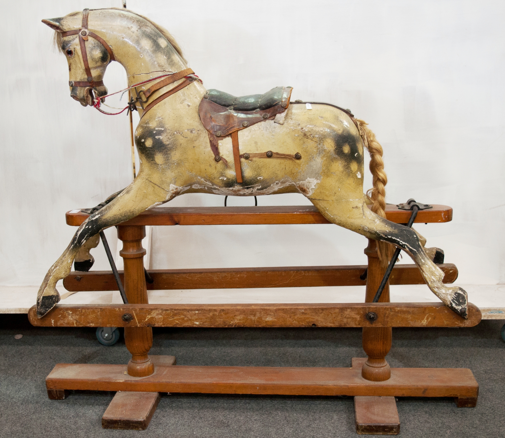 Victorian rocking horse, carved and painted wood, on a stained pine trestle base, length 112cms,