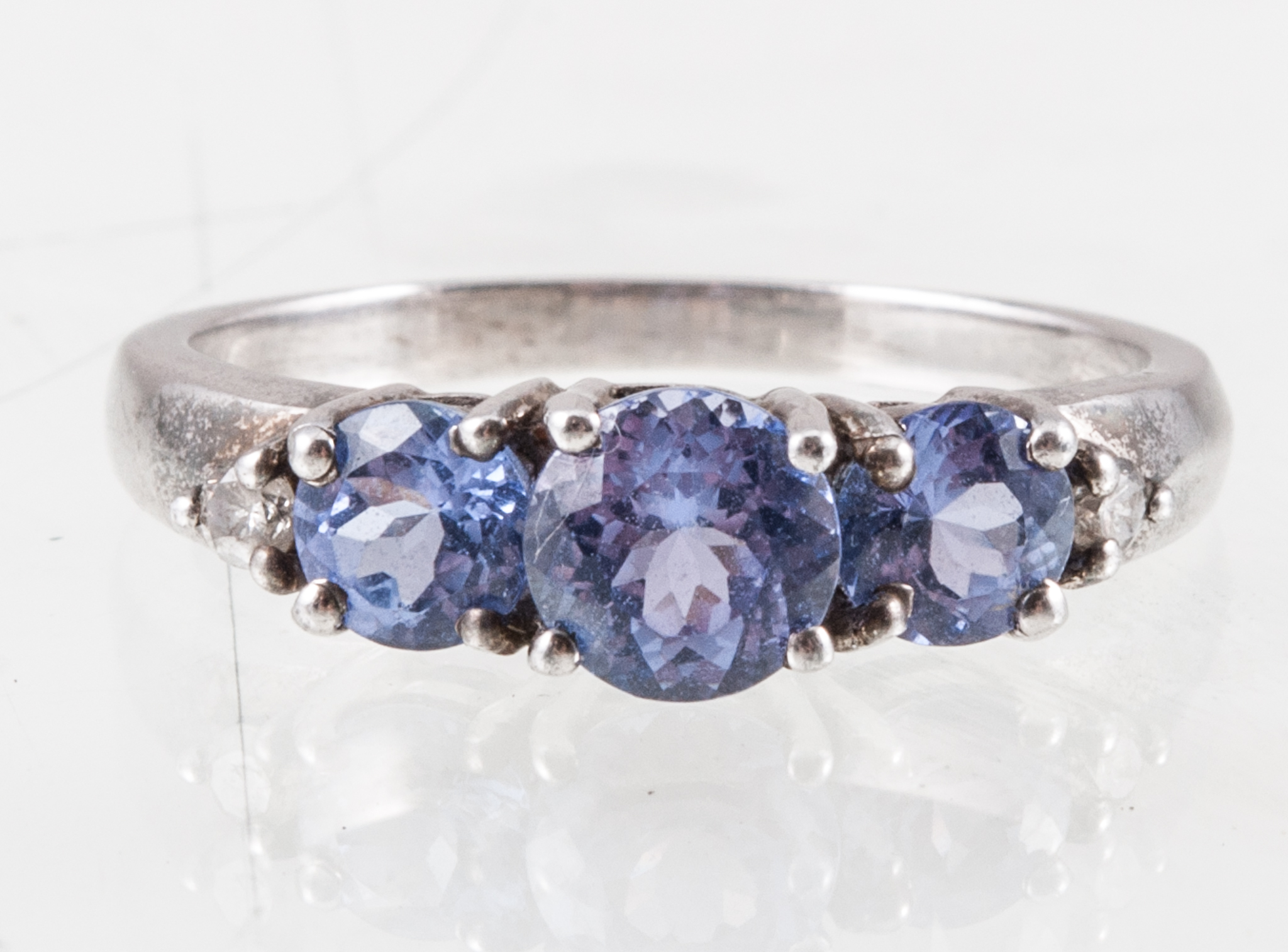 A tanzanite dress ring, three brilliant cut tanzanite four claw set in a silver mount,