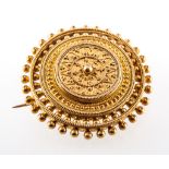 A yellow metal circular target design brooch,