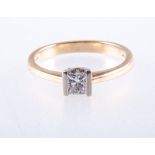 A diamond solitaire ring, the princess cut stone bar set in an 18 carat yellow and white gold mount,