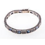 A gemset white metal line bracelet, eleven sapphires, oval and circular mixed cut stones,
