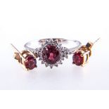 A Tanzanian ruby and diamond cluster ring and single stone earrings, one oval mixed cut ruby,