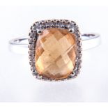 A citrine and diamond dress ring, a multi faceted gold citrine, rectangular cushion shape,