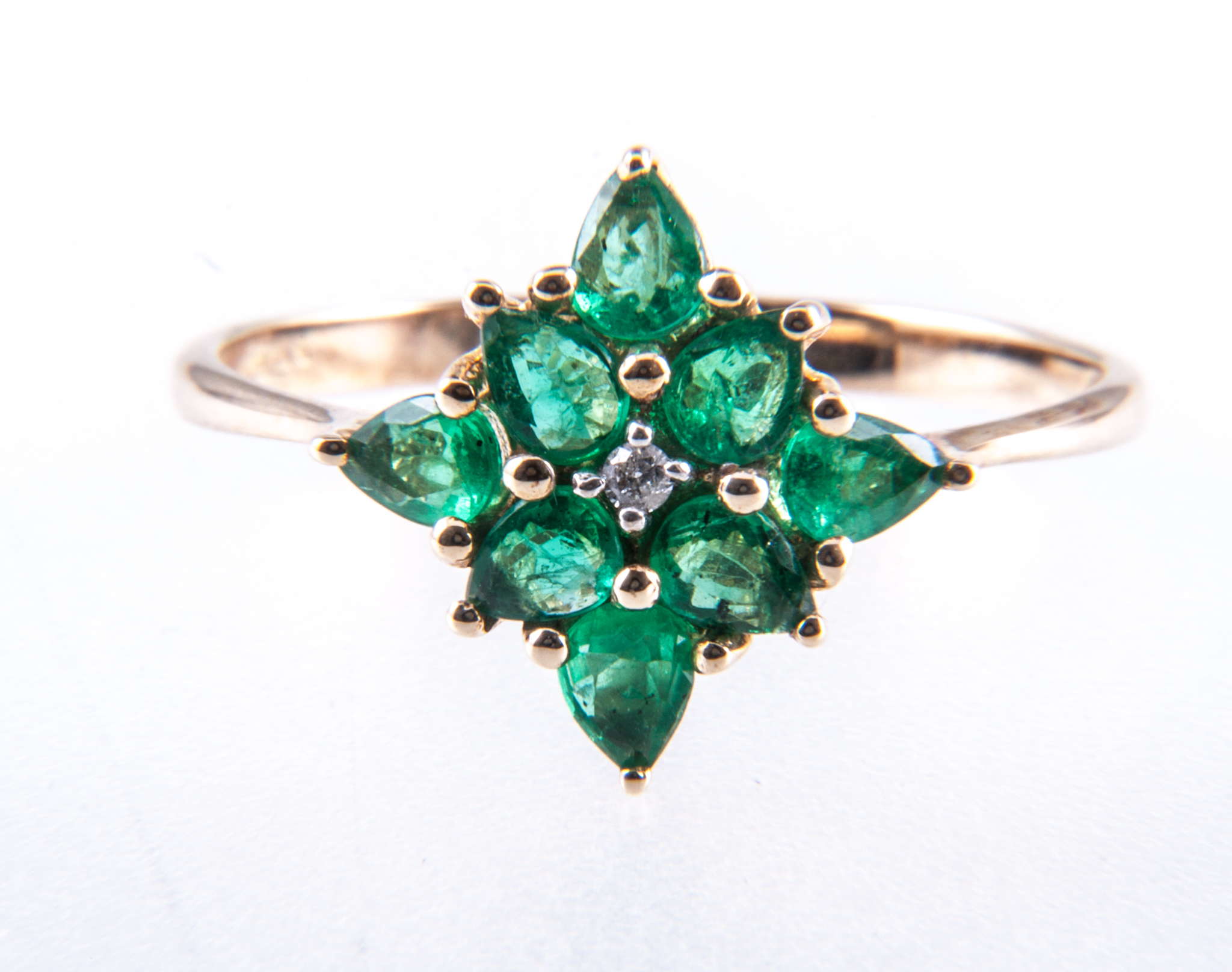 An emerald and diamond cluster ring, eight pear shaped emeralds, one brilliant cut diamond,