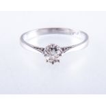 A diamond solitaire ring, the old brilliant cut stone claw set in a white metal mount,