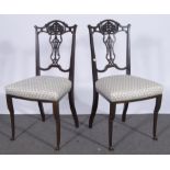 A pair of Edwardian stained walnut salon chairs, carved and shaped crestings,