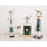 Collection of metal and plastic greyhound trophies.