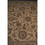 Zeigler style carpet, scrolling floral decoration on a faun ground, border within guards,