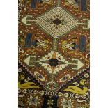 Iranian rug, rust ground with three lozenge medallions joined by poles,