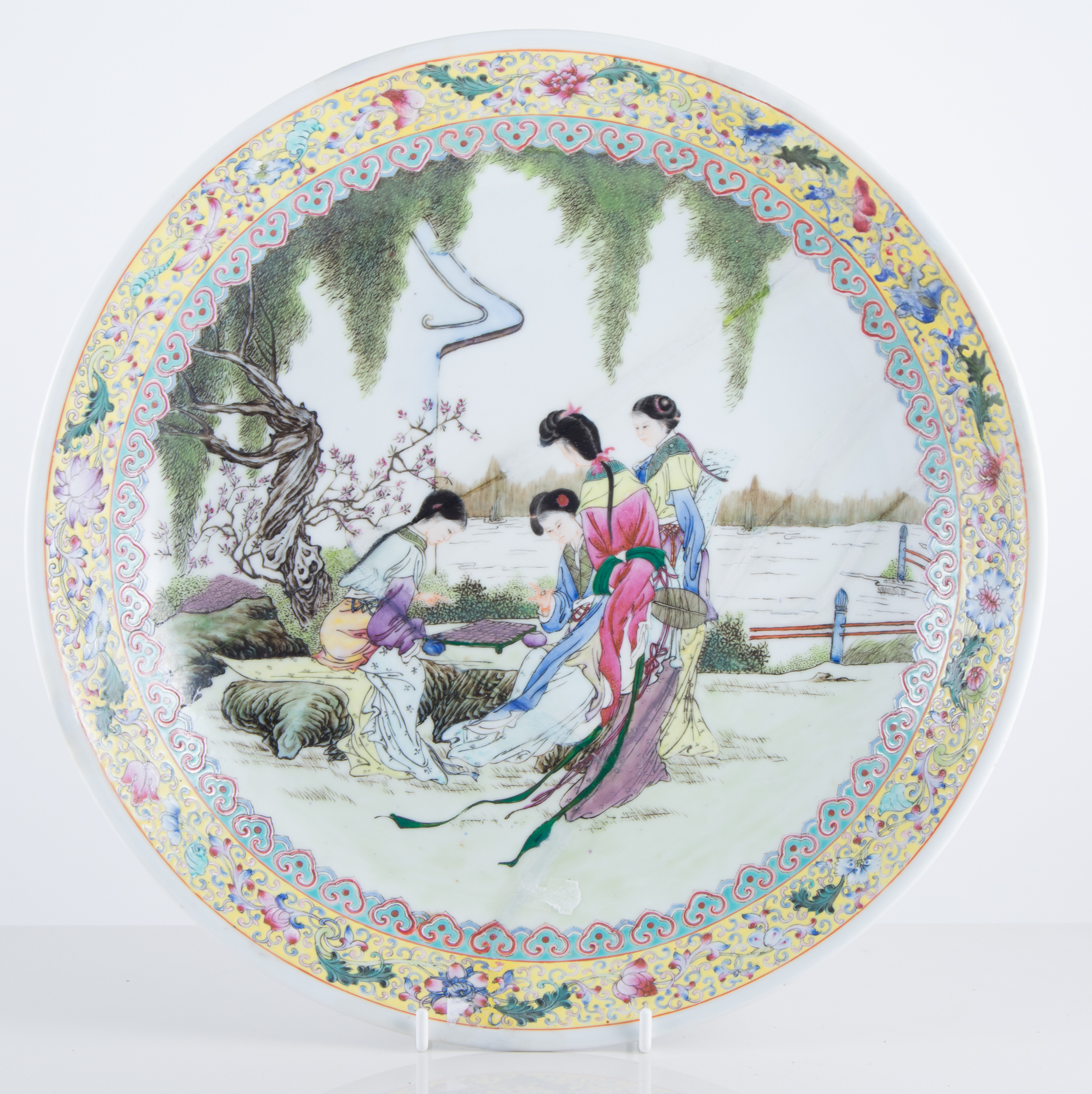 Chinese polychrome dish, shallow circular form, decorated with women by a riverside, restored,