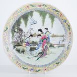 Chinese polychrome dish, shallow circular form, decorated with women by a riverside, restored,