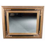 Contemporary wall mirror, rectangular bevelled plate, gilt and ebonised scrolled frame,