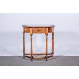 A reproduction demi-lune side table, turned columns joined by stretchers, W71cm x D39cm x H71cm.