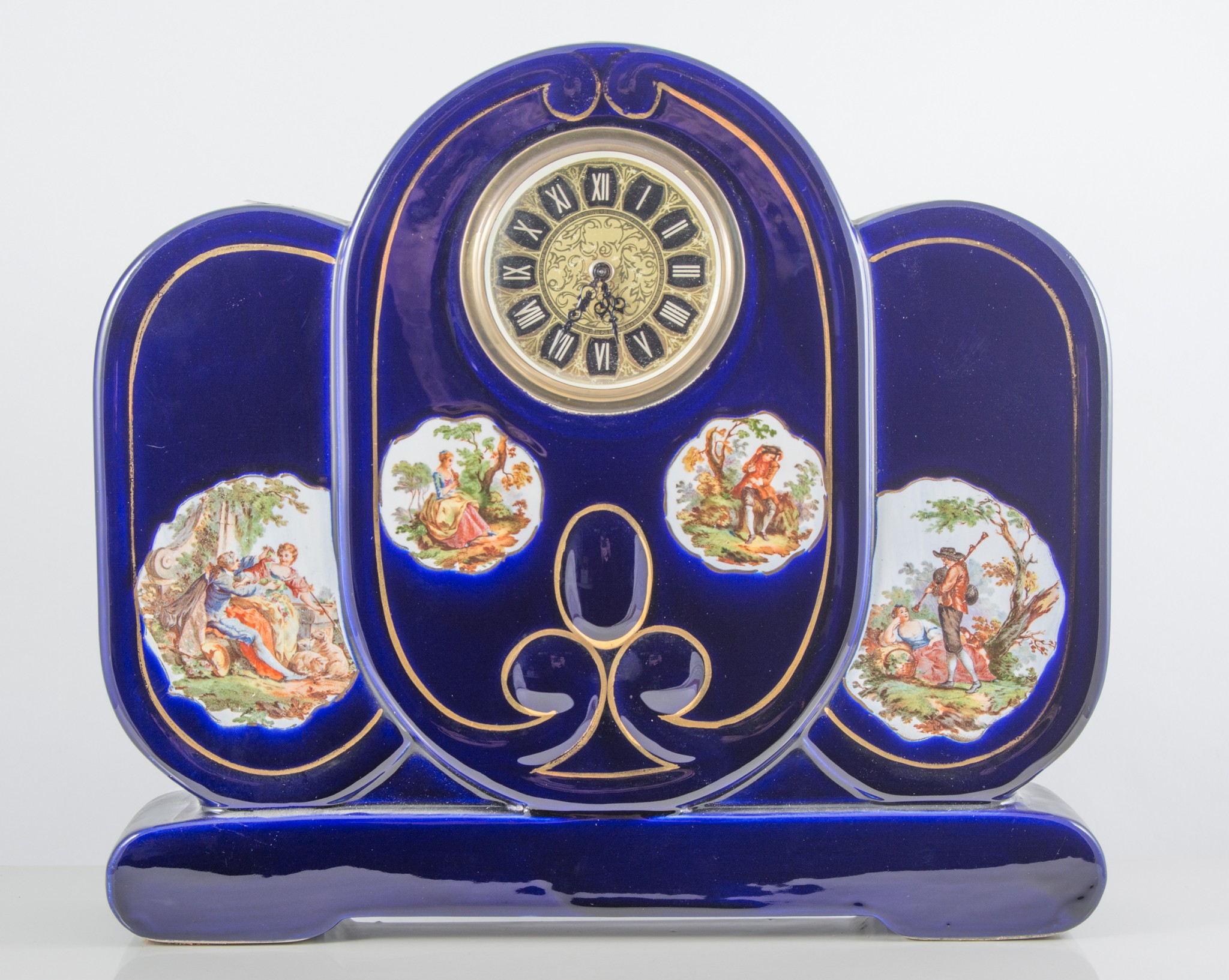A blue glazed pottery three piece clock garniture, printed reserves, later dial, 30cm.
