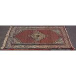A worn rug, strawberry field with central medallion, closed by spandrels with broad borders,