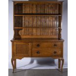 An oak Arts and Crafts style dresser, the back with two shelves above a rectangular top,