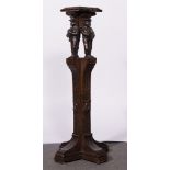 Continental carved and stained oak torchere, carved with four musical figures, height 101cm.