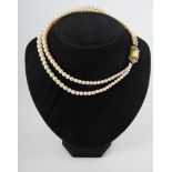 A two row cultured pearl necklace with diamond snap, cultured pearls (67) and (71),