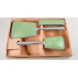 Two boxed dressing table brush sets, a "Two Tix" green enamel set,