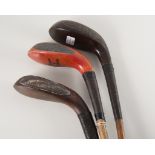 Three vintage hickory shafted golf clubs - a long nose wooden headed club with horn inset,