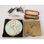 Two powder compacts, one having a flying mallard to cover,