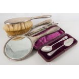 Silver backed dressing table set, comprising a hand mirror, two hair brushes and a clothes brush,