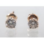 A pair of diamond single stone earrings, one brilliant cut half carat diamond four claw set to each,