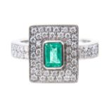 An emerald and diamond rectangular cluster ring, the rectangular step cut emerald 5.2mm x 3.