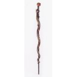 A Tribal cane, skull carved grip, the cane with a carved and painted coiled snake, 92cms.