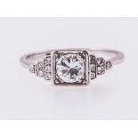 A diamond solitaire ring, the brilliant cut stone square set in an all white metal mount,