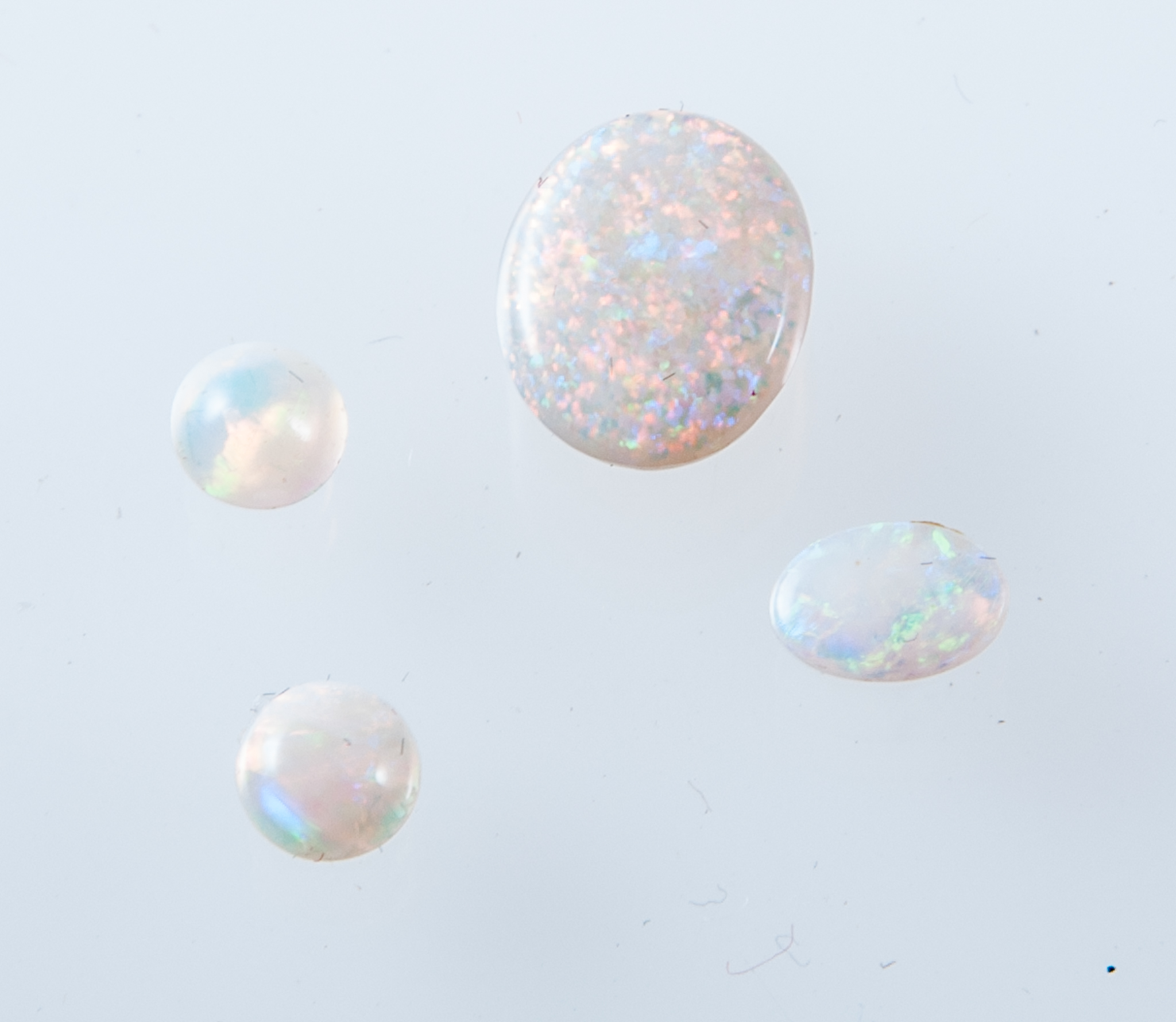 Four loose opals, two oval cabochon cut, 10mm x 8.2mm, 6.2mm x 4.