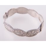A silver solid double curb link bracelet, four charms attached, hallmarked London 1974,