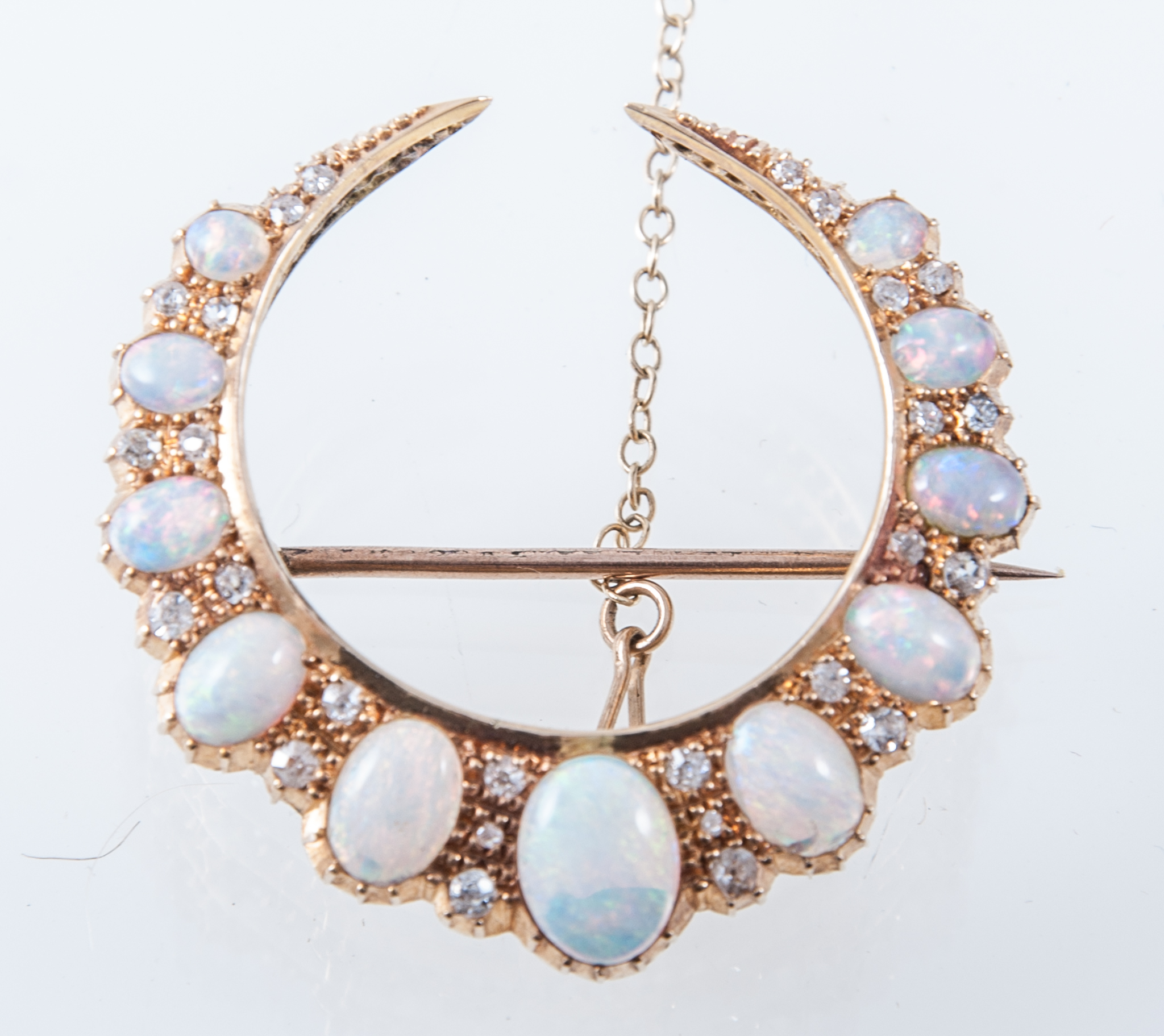 An opal and diamond closed crescent brooch,