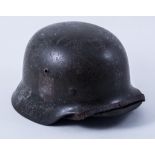 A German helmet, the left side with eagle and swastika decal, the right side with indistinct decal,
