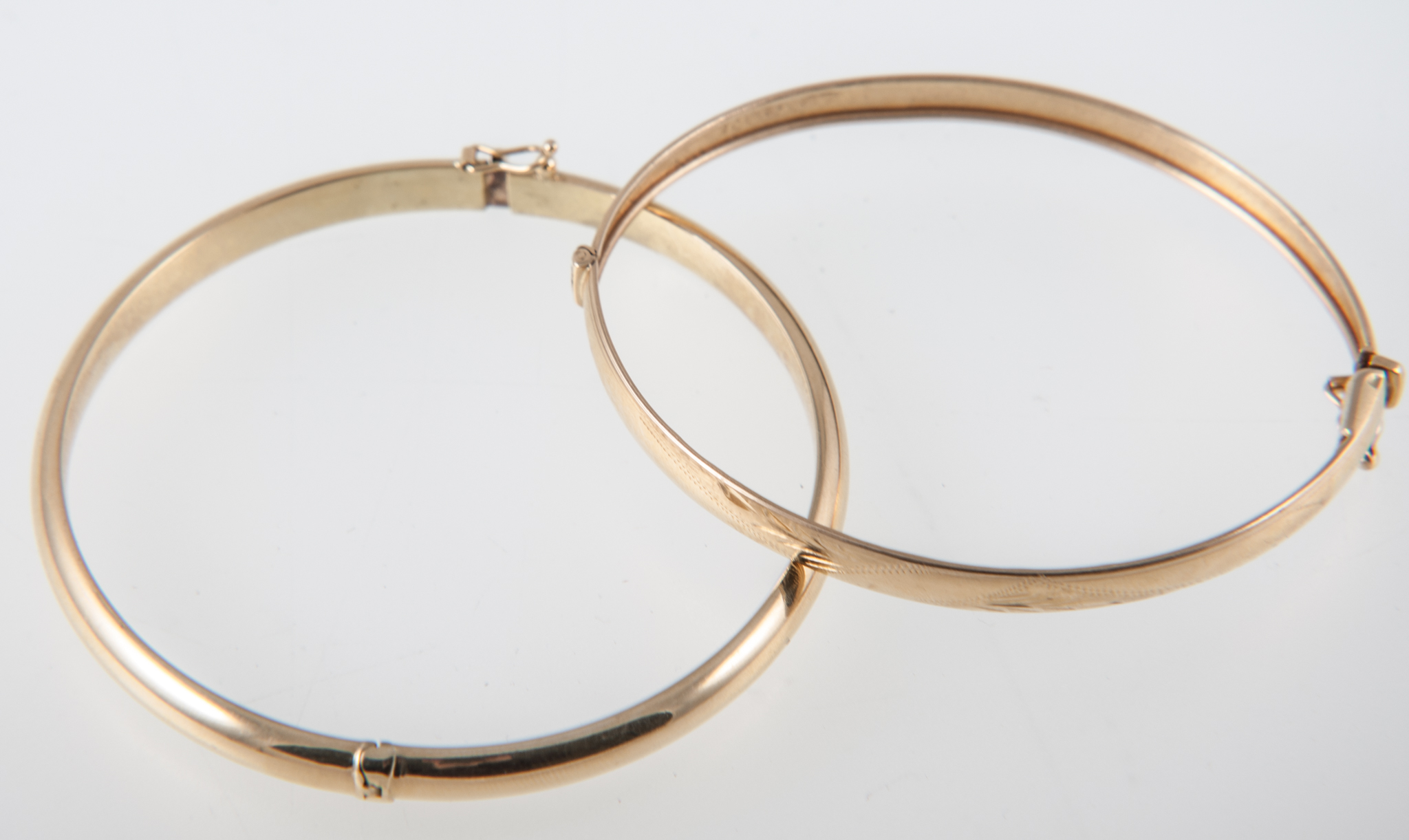 Two 18 carat yellow gold half hinged bangles, one a 6mm wide plain polished design, the other 5.