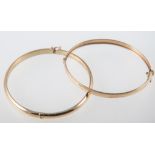 Two 18 carat yellow gold half hinged bangles, one a 6mm wide plain polished design, the other 5.