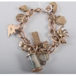 A 9 carat rose gold solid elongated curb link bracelet with nine charms attached to include a