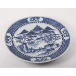 Chinese blue and white pottery charger, painted with figures on abridge in a mountain landscape,